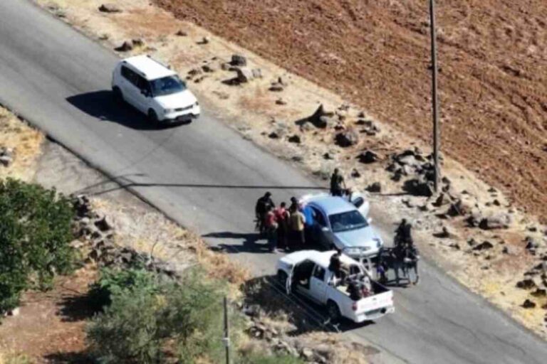 Syria Druze violence, fighters walk near destroyed military vehicles after Syria Druze violence in Sweida escalates severely.