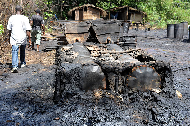 Boats and oil drums at an illegal oil bunkering site being dismantled by Nigerian security forces