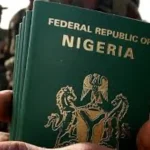 Nigeria passport showing NIS emblem and updated passport fees with official government logo for travelers