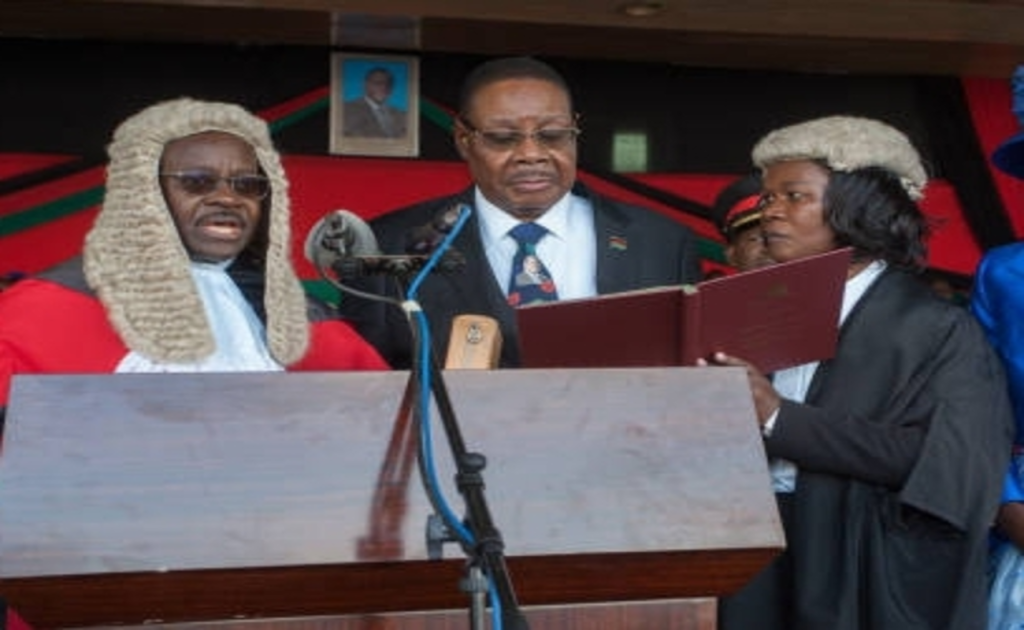 Malawi’s returning president Peter Mutharika vows 'no more looting government' | Epicstorian News Peter Mutharika holds Bible during swearing-in ceremony at Kamuzu Stadium in Blantyre, Malawi, October 4, 2025.