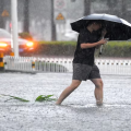 Flooded road in Haikou as residents wade through heavy rain after Typhoon Matmo hit southern China.