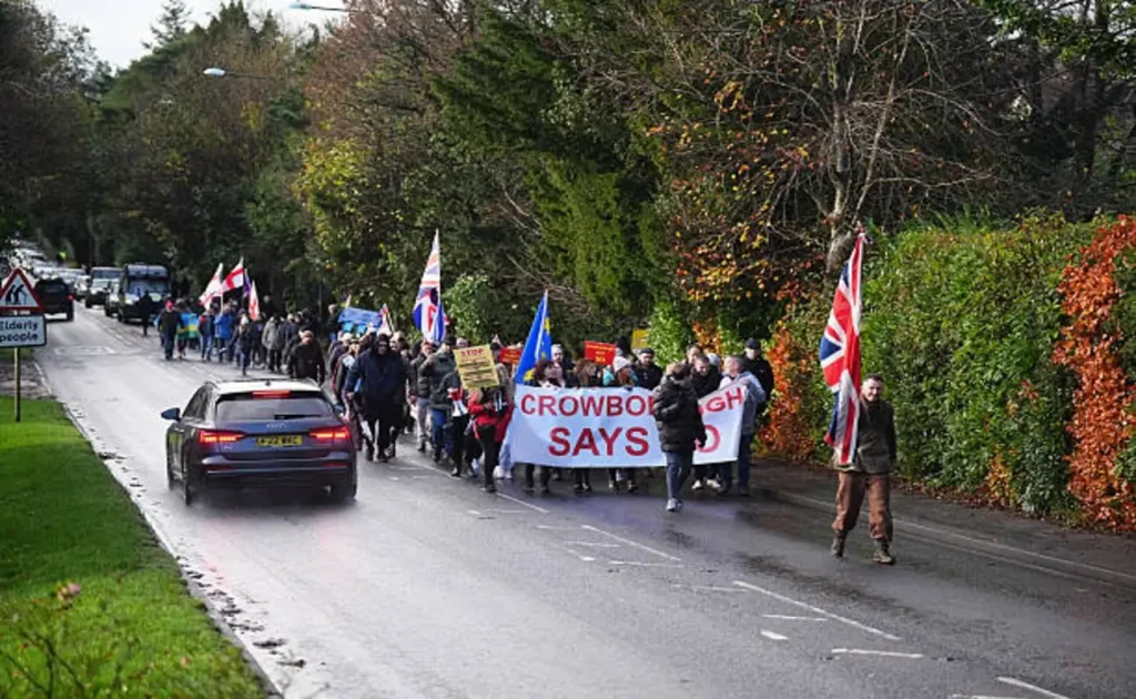 Crowborough Residents Rally as UK Prepares Army Camp for Asylum Seekers | Epicstorian News Crowborough protesters gather during a large demonstration against plans to house asylum seekers at the nearby military camp.