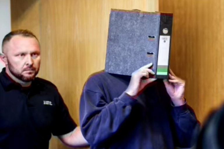 German nurse covers face while arriving at Aachen court before life sentence ruling for killing patients