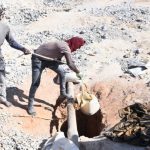 Illegal mining activity near Durban Deep mine showing miners sifting gold from tailings in Johannesburg, South Africa.