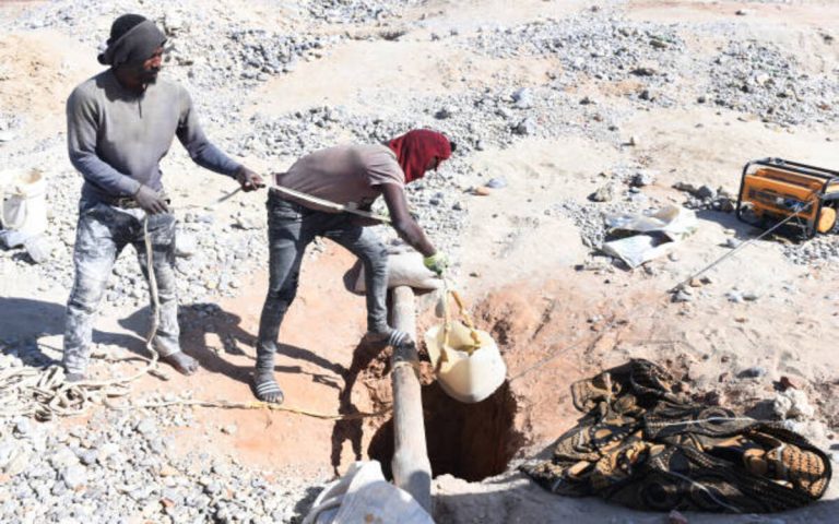 Illegal mining activity near Durban Deep mine showing miners sifting gold from tailings in Johannesburg, South Africa.