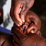 A health worker reviews Nigeria malaria cases data charts inside a rural clinic during national disease surveillance efforts.