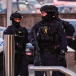 Police cordon at Bondi Beach after Bondi Beach attack with emergency responders and investigators aiding victims.