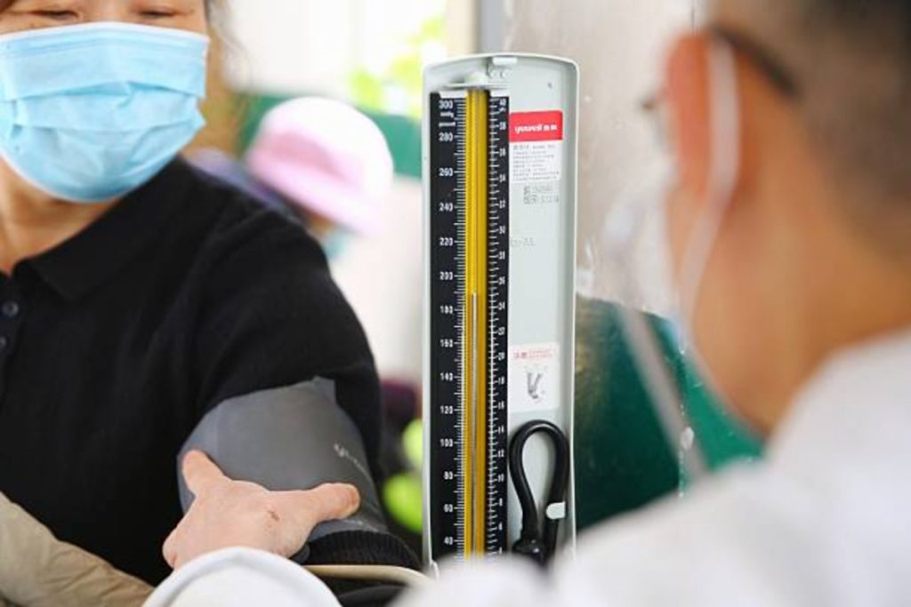 Global Chronic Diseases Surge, Driving Healthcare Costs Higher, WHO Says | Epicstorian News Healthcare worker measures residents’ blood pressure using mercury monitor in Tengzhou City, Shandong Province, China, December 2025.