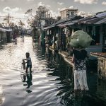 A woman wades the flooded neighborhood with her child ilafter Cyclone Gezani struck Madagascar on February 12, 2026