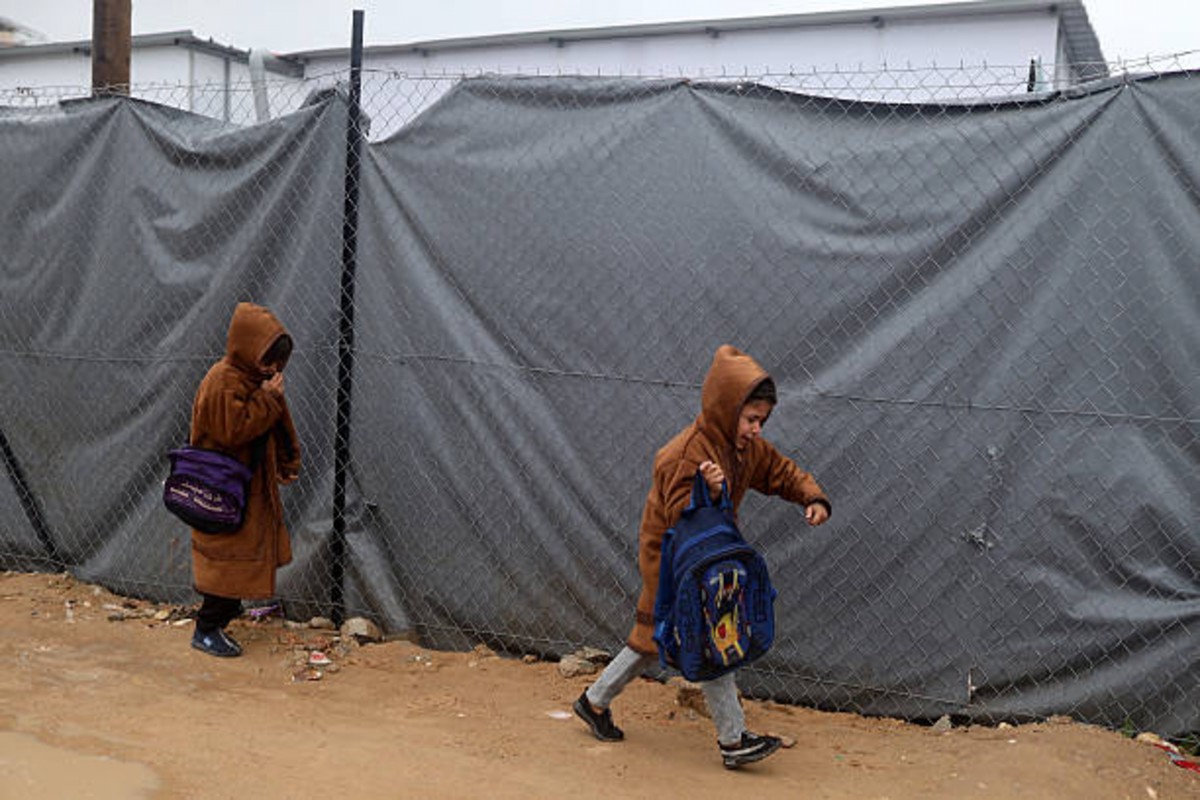 Palestinian children sit at desks attending class inside a temporary caravan school in Gaza City amid post-conflict education recovery efforts